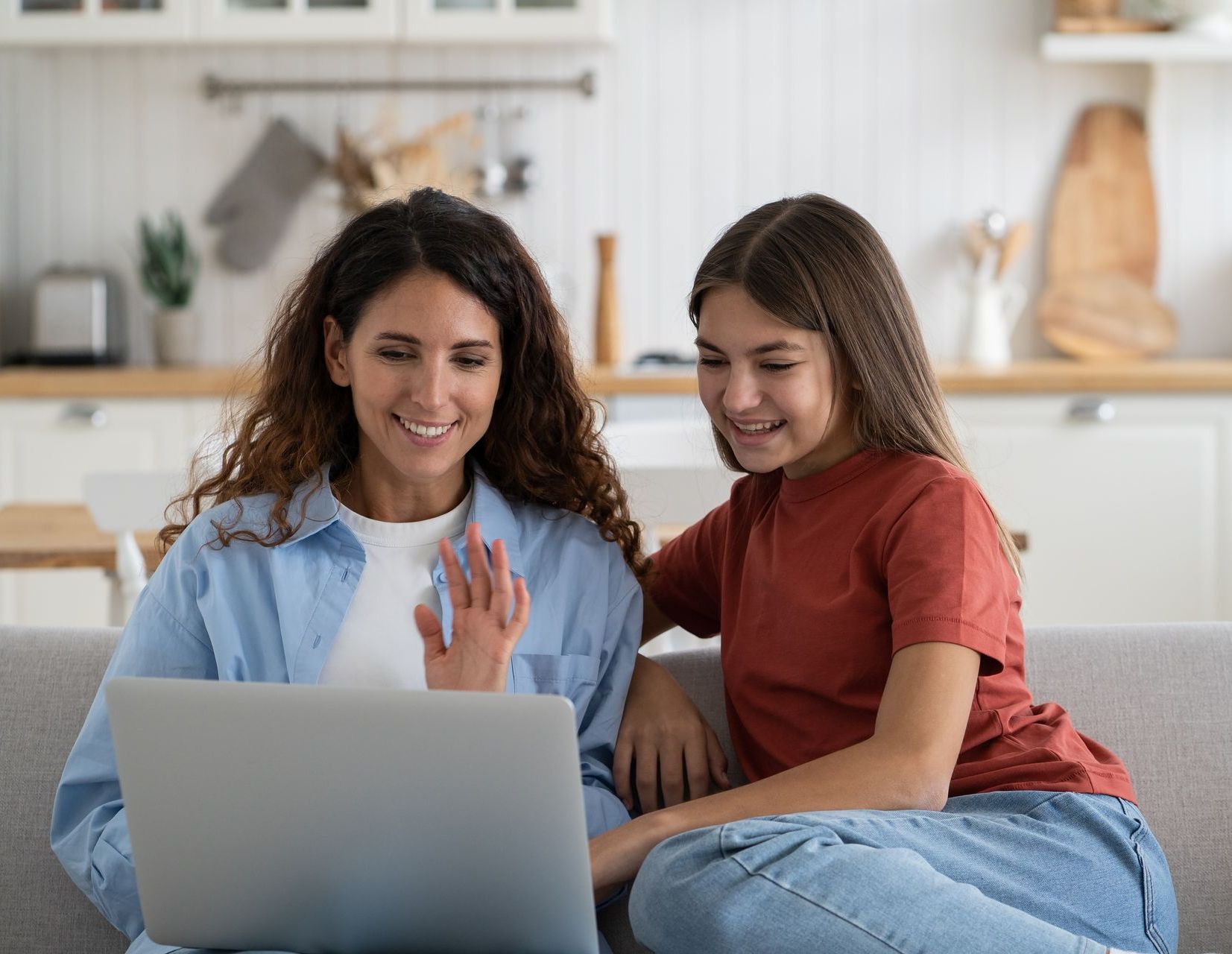 A mother and daughter with launch anxiety are sitting on a couch using a laptop computer in a one-on-one session with licensed therapist roya dedeaux.