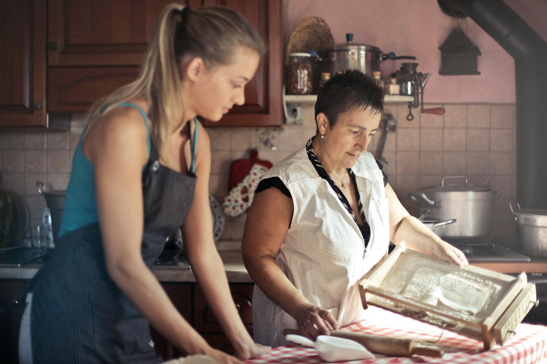 Teenage girl in kitchen cooking with mom.