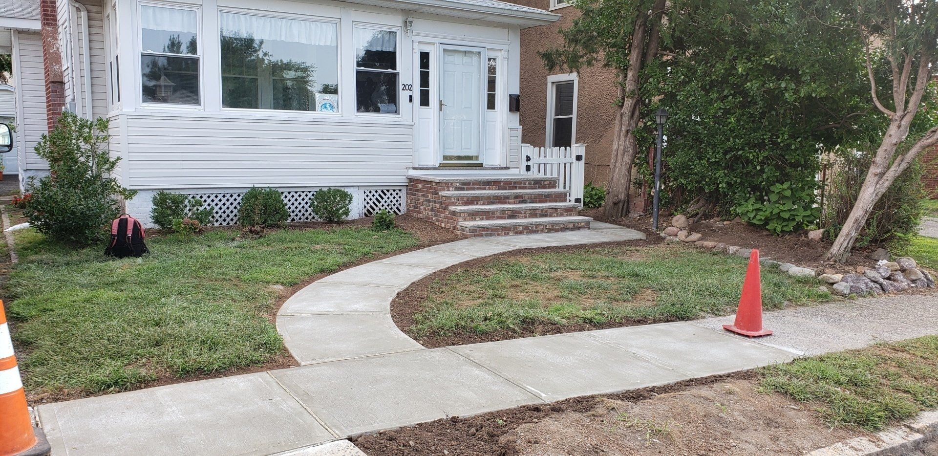 A concrete walkway is being built in front of a house.