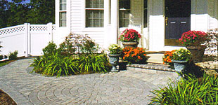 A white house with a brick walkway leading to the front door.