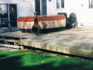 A wooden deck with a  hot tub on it