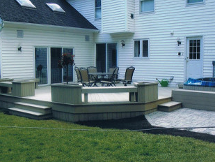 A patio with a table and chairs in front of a house.