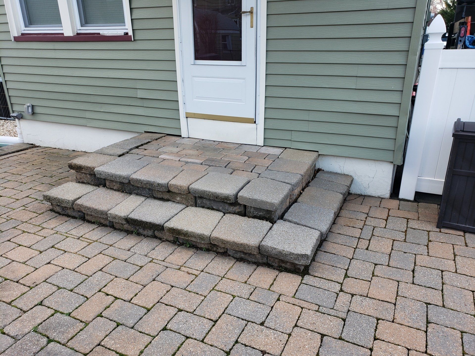 A brick walkway with steps leading up to a house.