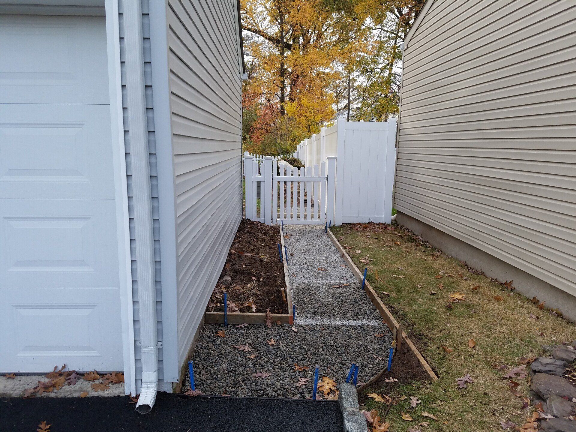 A sidewalk is being built between two houses.