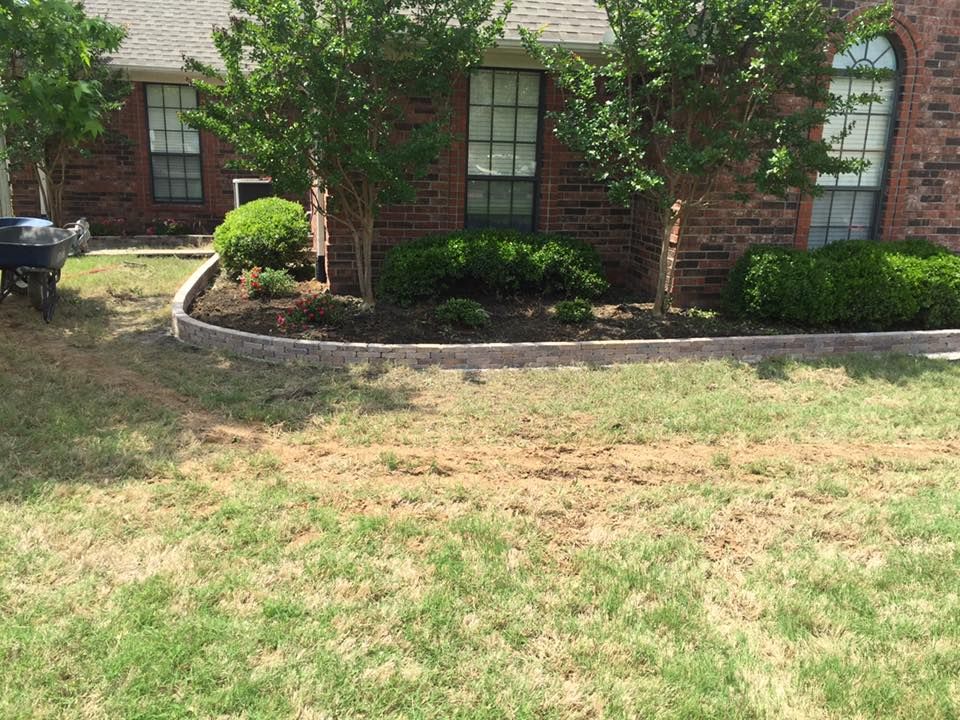A brick house with a lush green lawn in front of it.