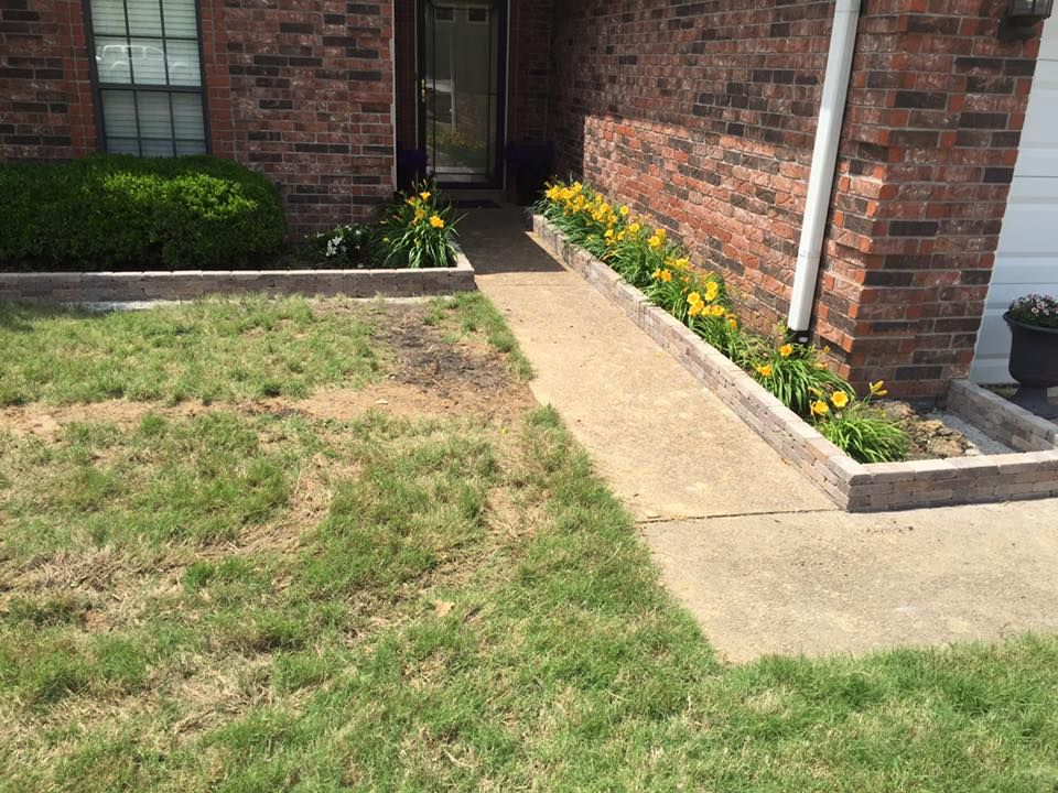 A brick house with a walkway leading to the front door