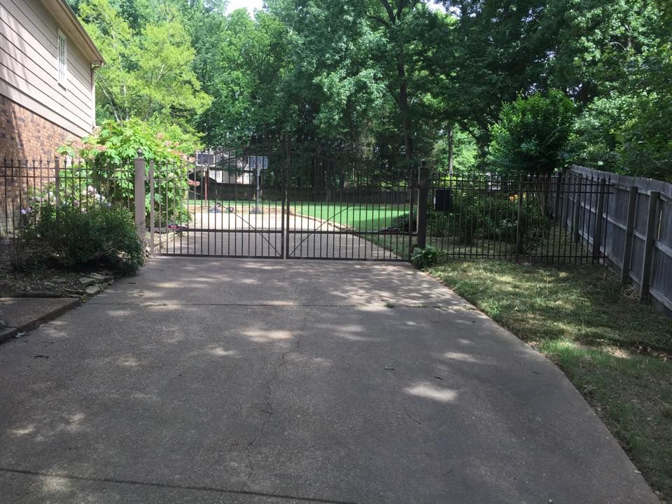 A driveway leading to a house with a gate
