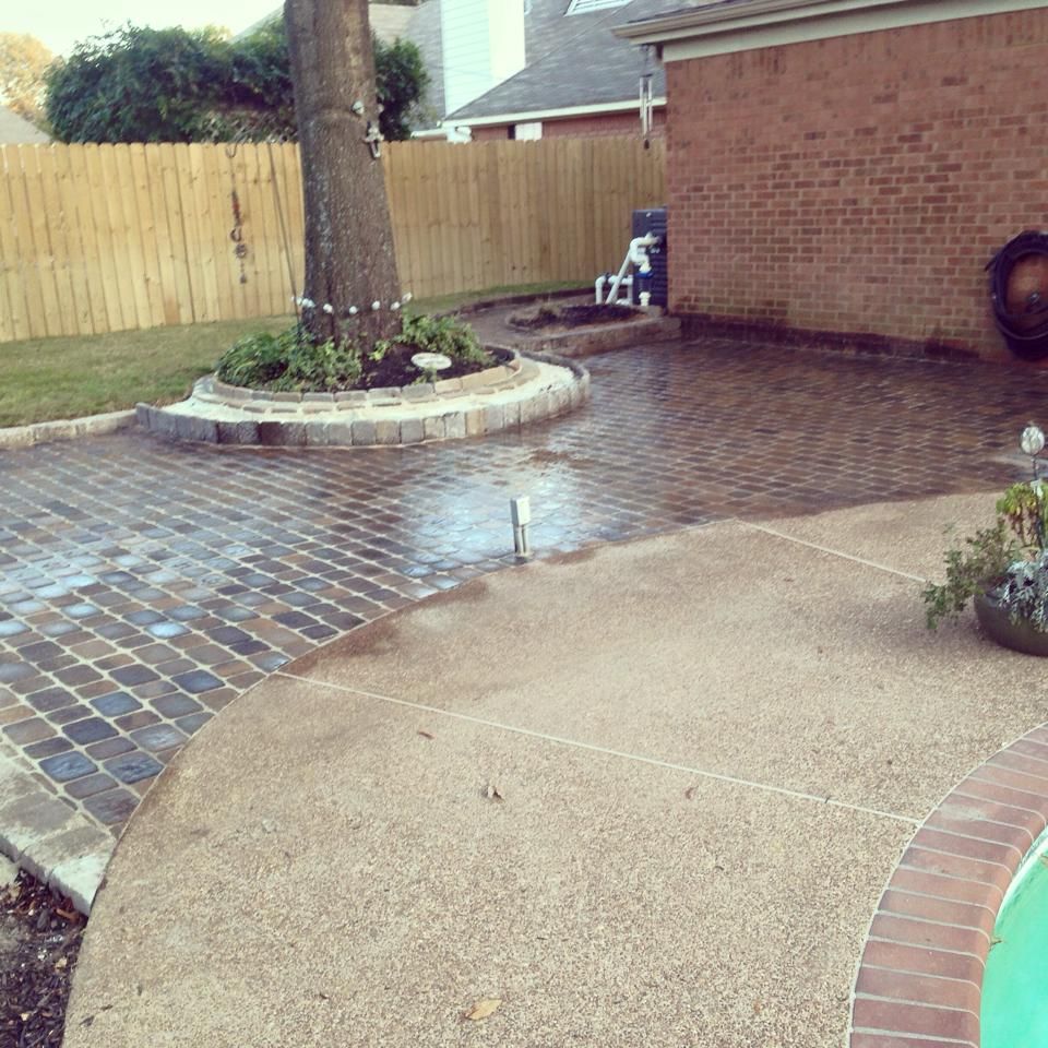A brick patio with a tree in the middle of it