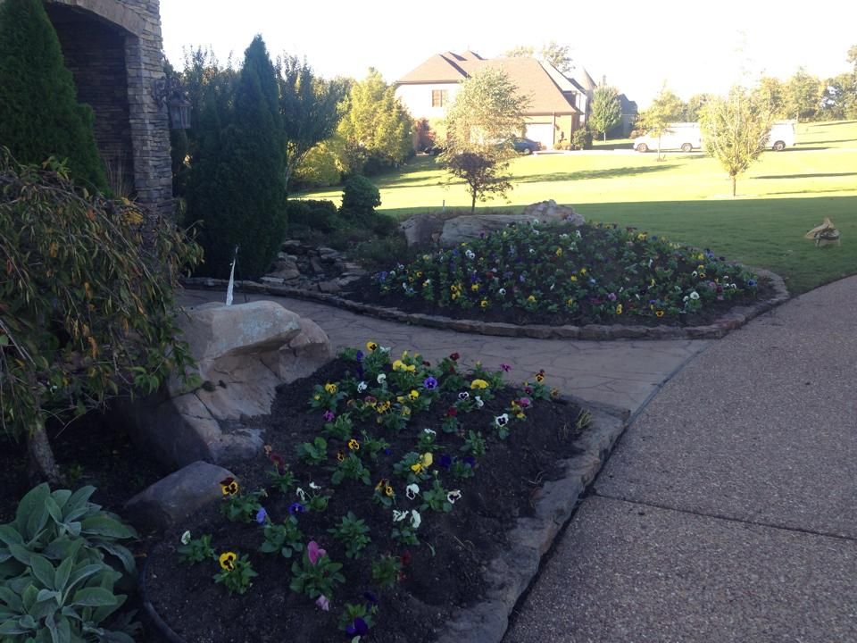 A sidewalk with flowers and a house in the background