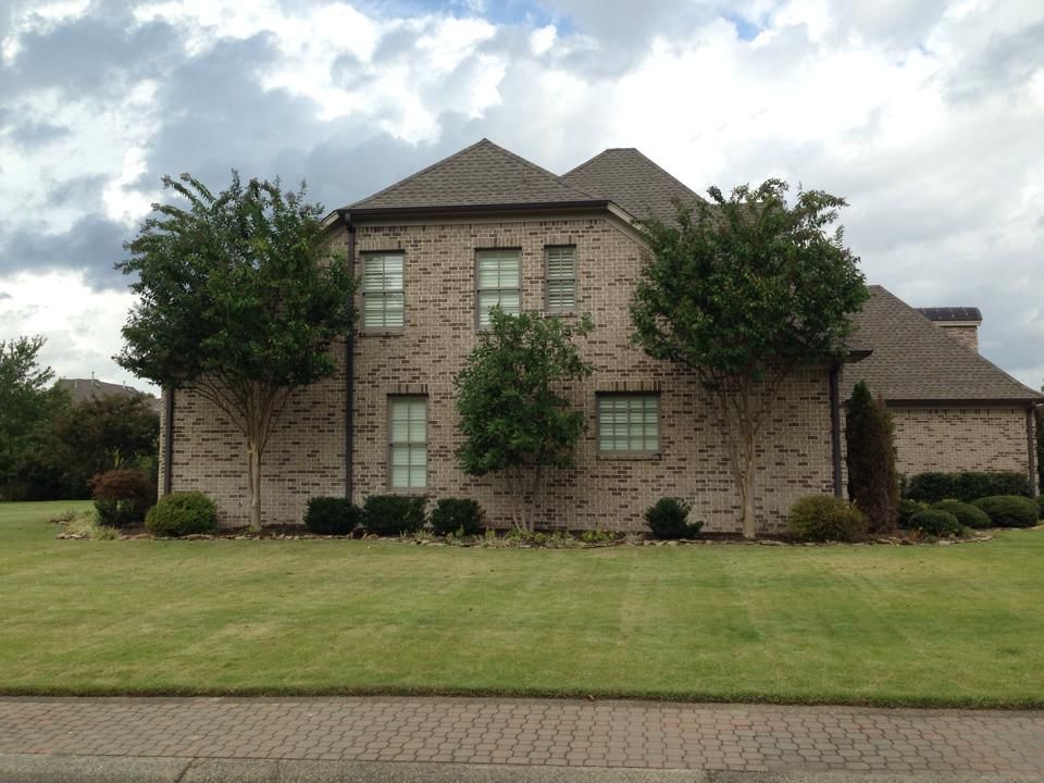 A large brick house with trees in front of it