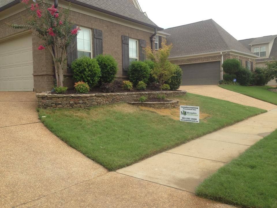 A house with a sign on the sidewalk in front of it