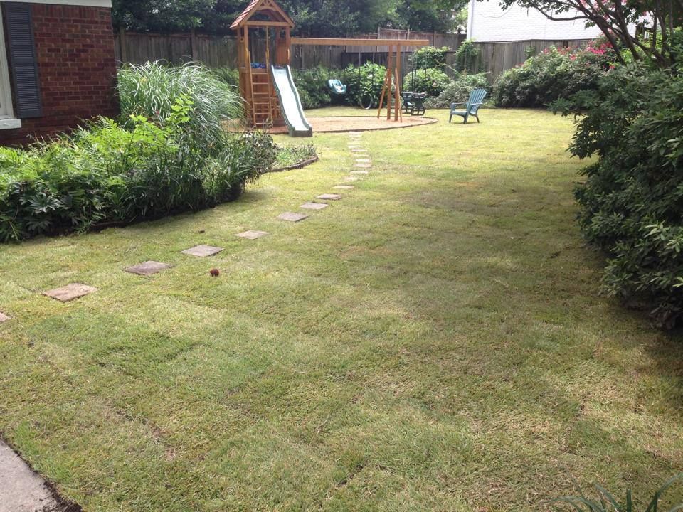 A backyard with a playground and a slide in it.