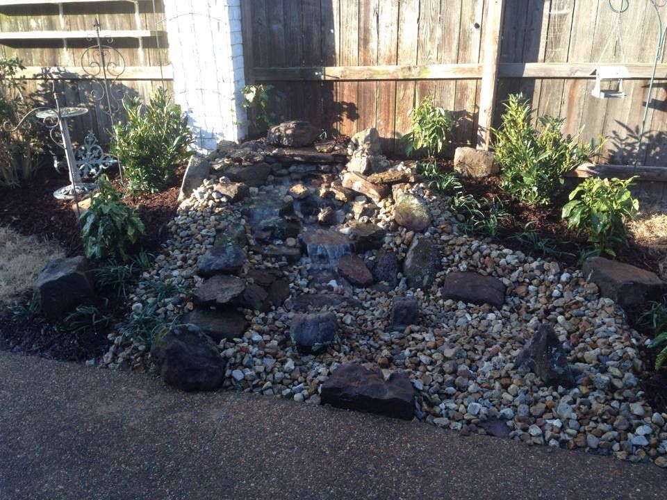A rock garden with a wooden fence in the background