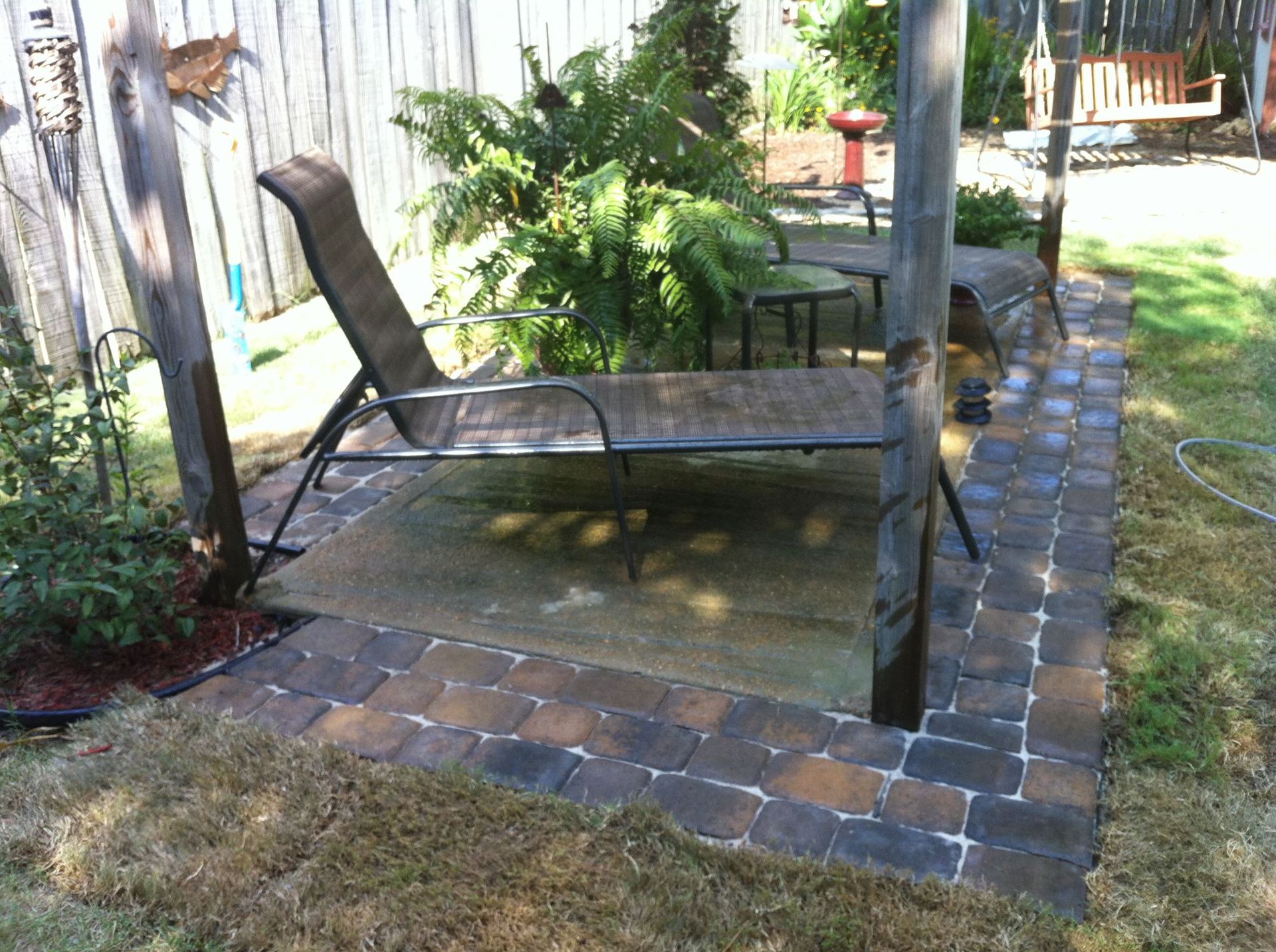 A patio area with a lounge chair and a table