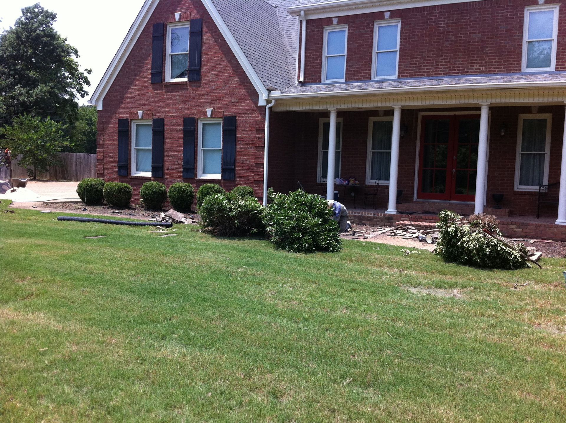 A large brick house with a large lawn in front of it