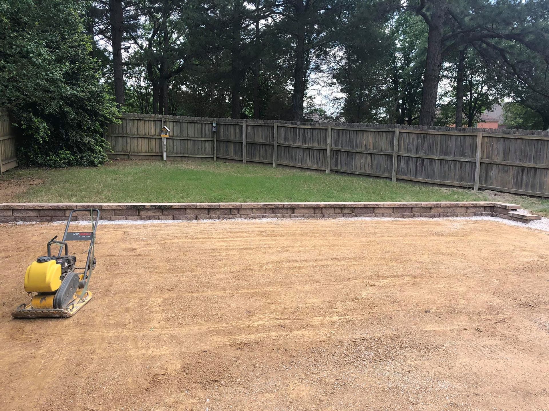 A yellow machine is sitting in the middle of a dirt field.