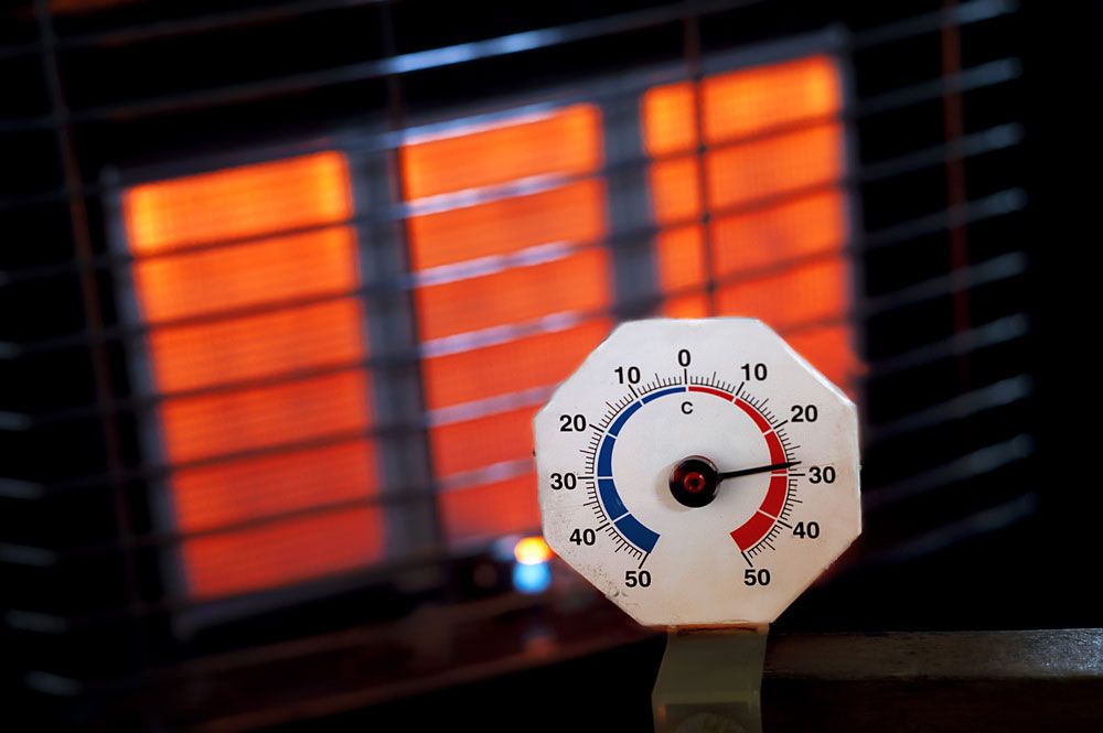 A Thermometer Is Sitting In Front Of A Heater That Is Turned On — PalmAir Heating & Cooling Specialists In Wagga Wagga, NSW
