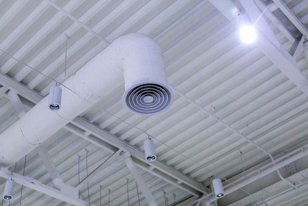 A White Air Duct Is Hanging From The Ceiling Of A Building — PalmAir Heating & Cooling Specialists In Tumbarumba, NSW