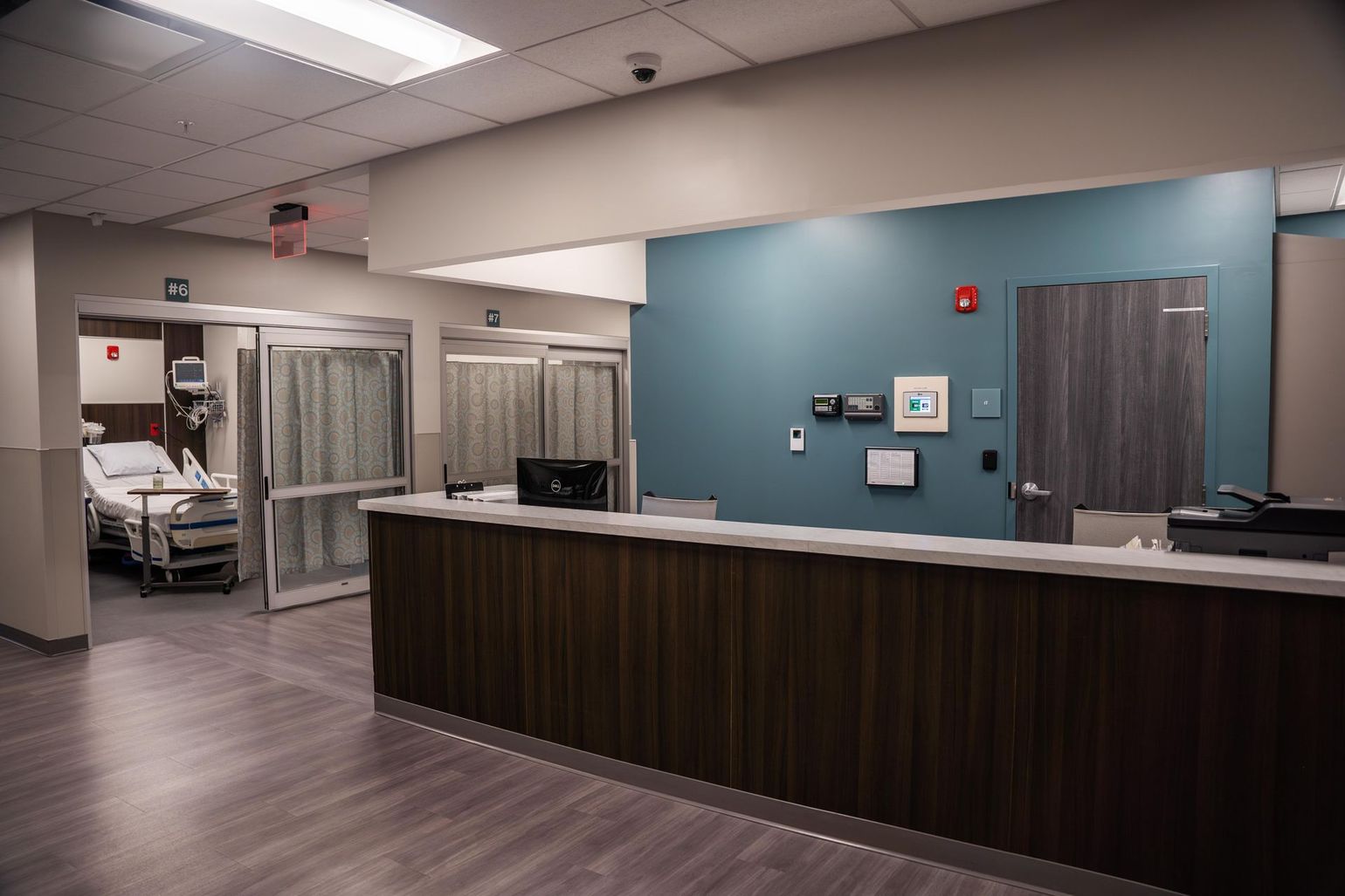a hospital room with a nurse 's station and a hospital bed .
