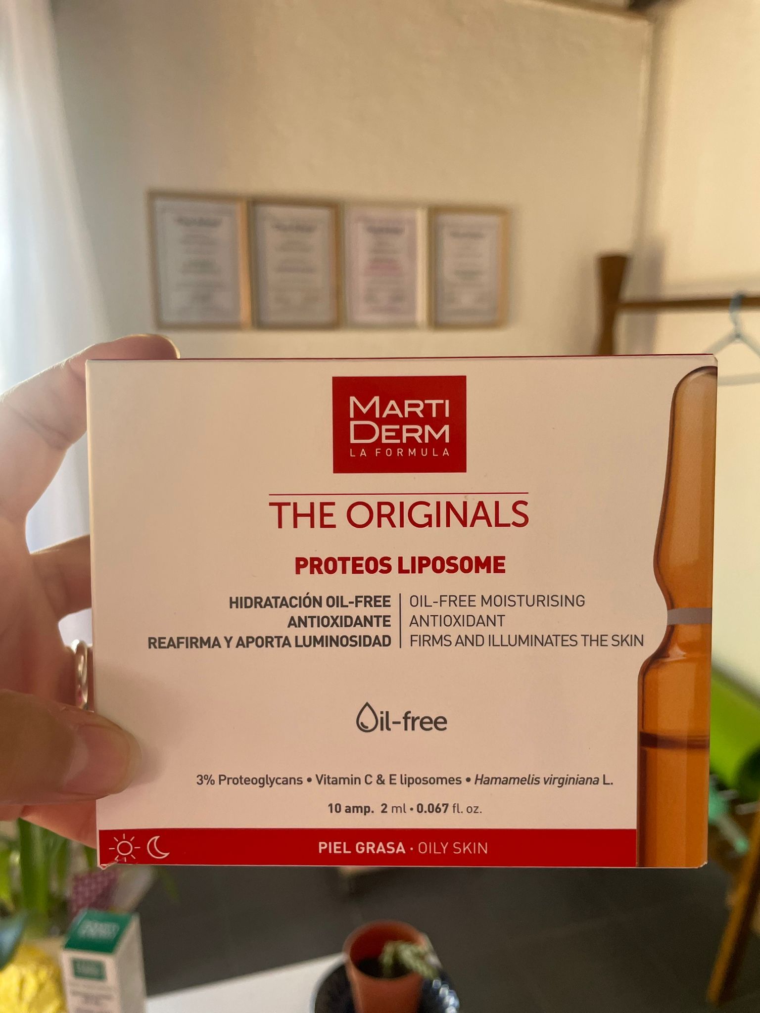 Mano sosteniendo una caja de productos para el cuidado de la piel Martiderm The Originals Proteos Liposome.