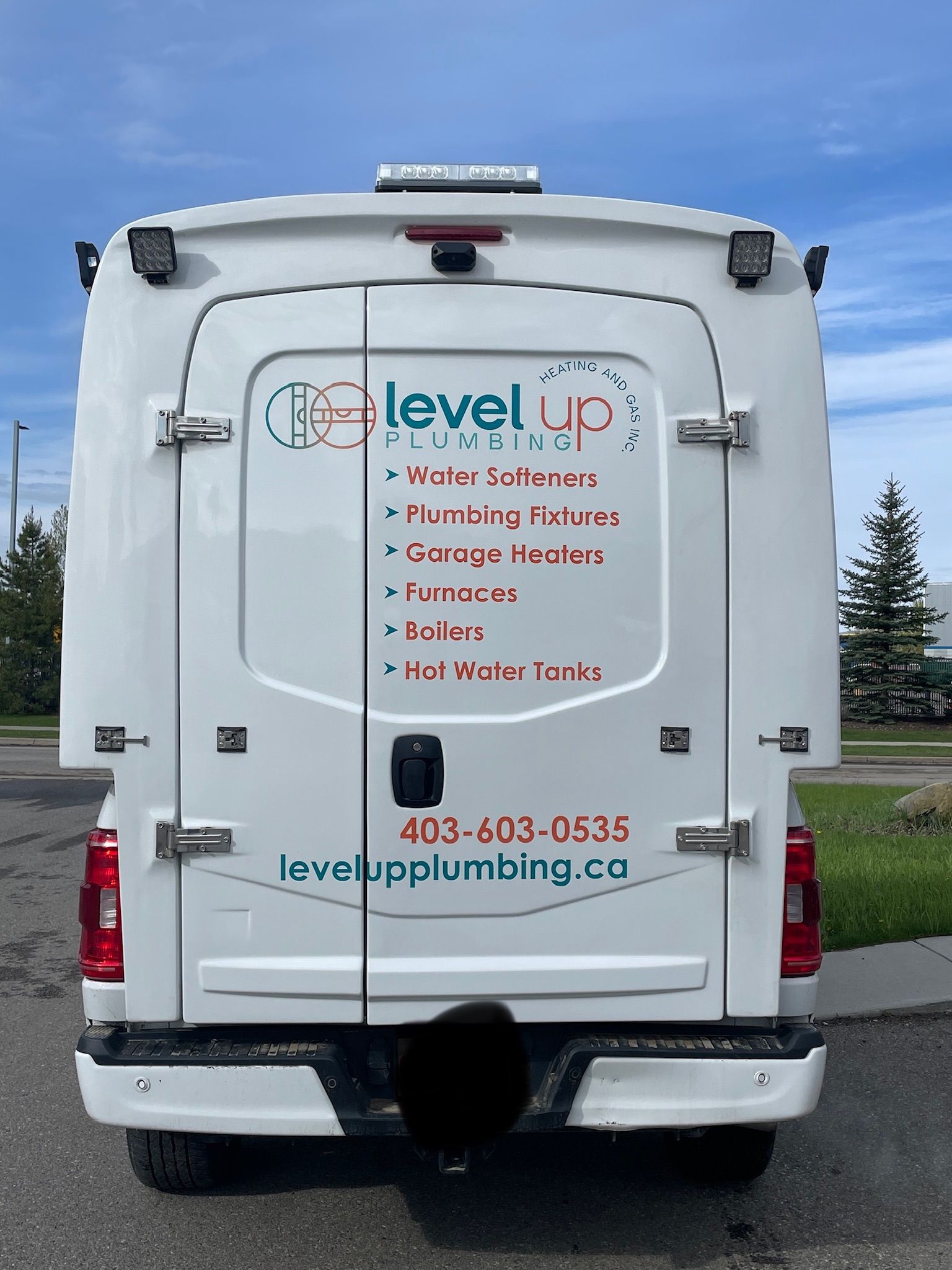 The back of a service vehicle branded with Level Up Plumbing decals and a list of services
