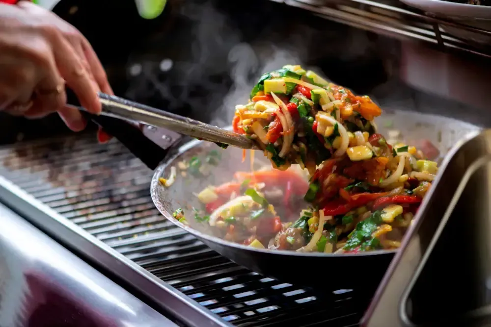 Why Choose Level Up Plumbing, Heating, and Gas For Your BBQ Gas Line Needs - frying vegetables on a gas grill.