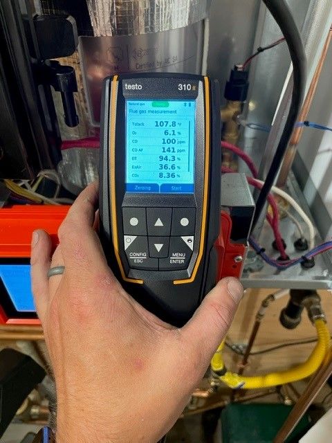 Technician using diagnostic tool and measuring furnace metrics