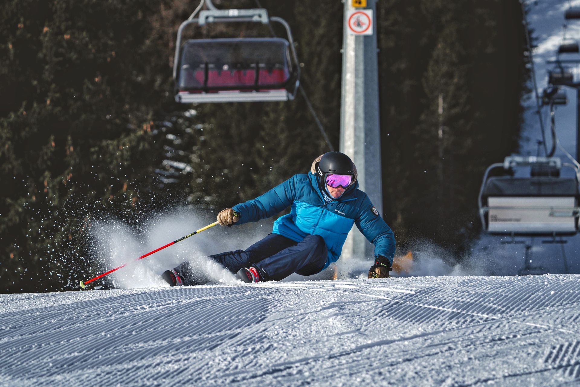 Una persona sta sciando lungo un pendio innevato accanto a uno skilift.