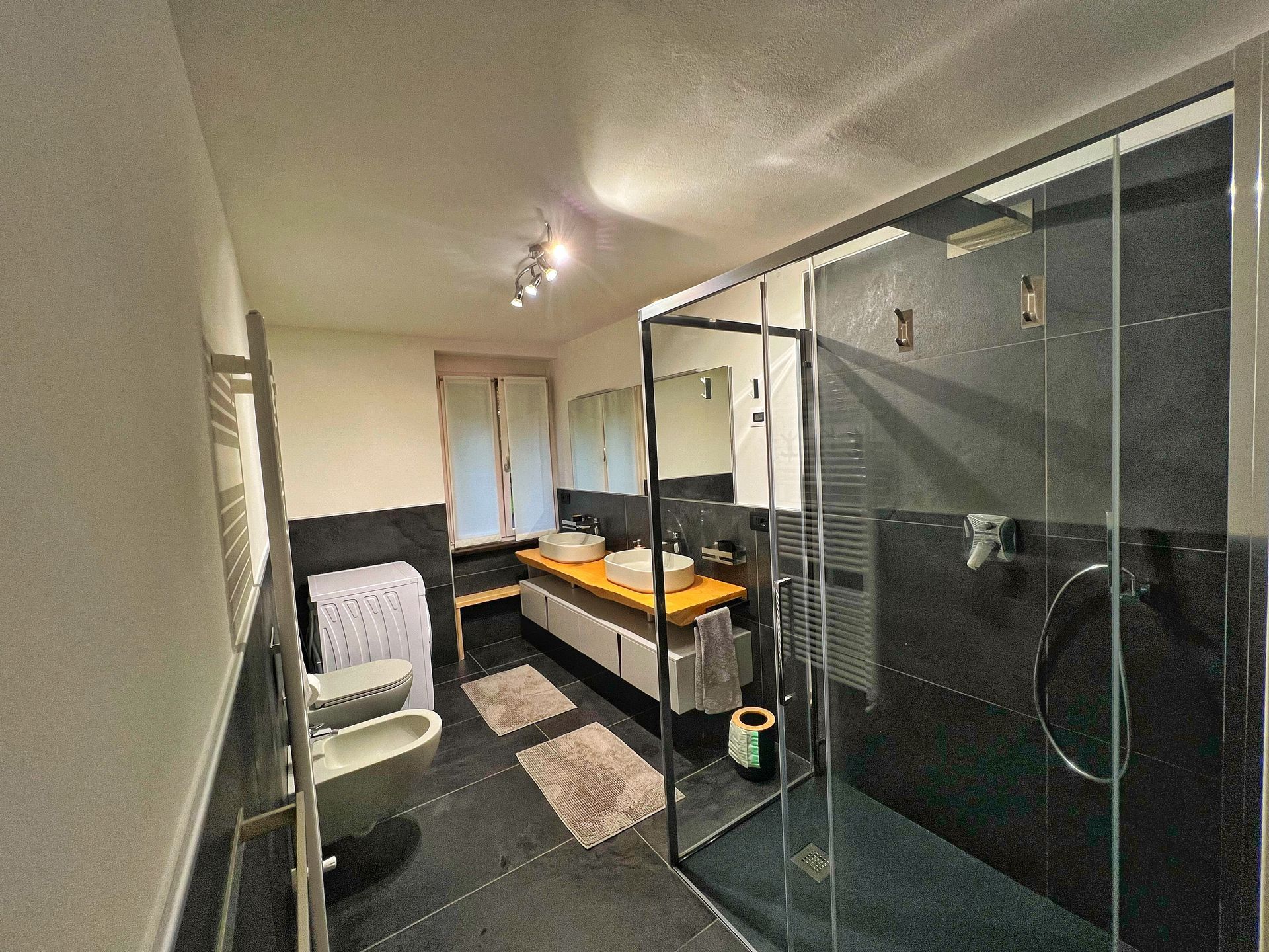 Un bagno con due lavandini, un water e una cabina doccia.