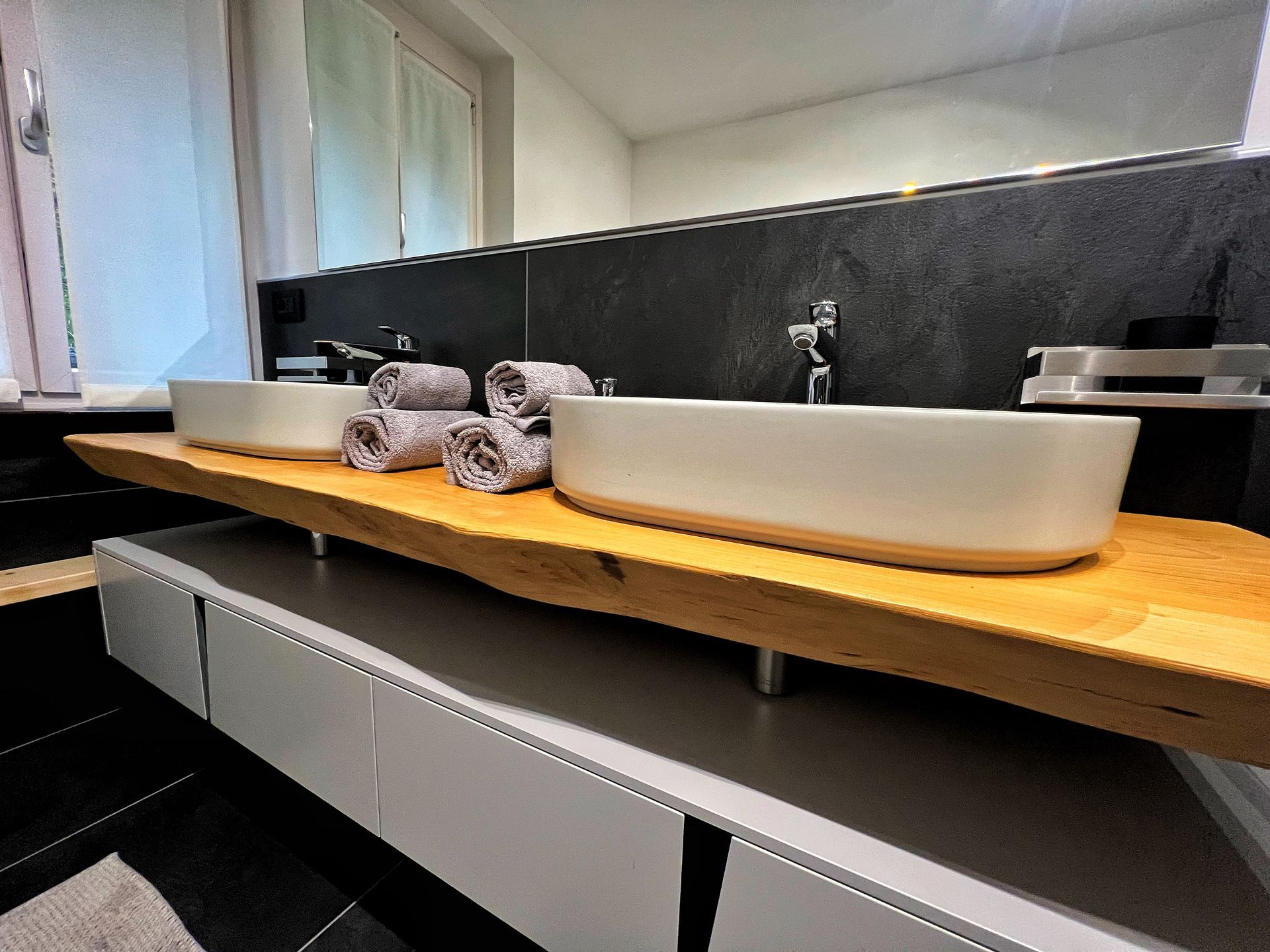 Un bagno con due lavandini e asciugamani sul tavolo