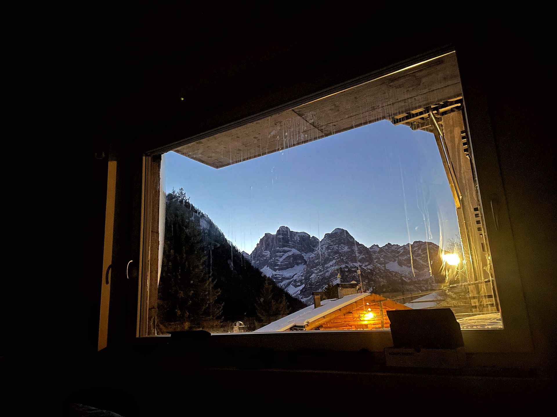 Una finestra con vista su una catena montuosa di notte.
