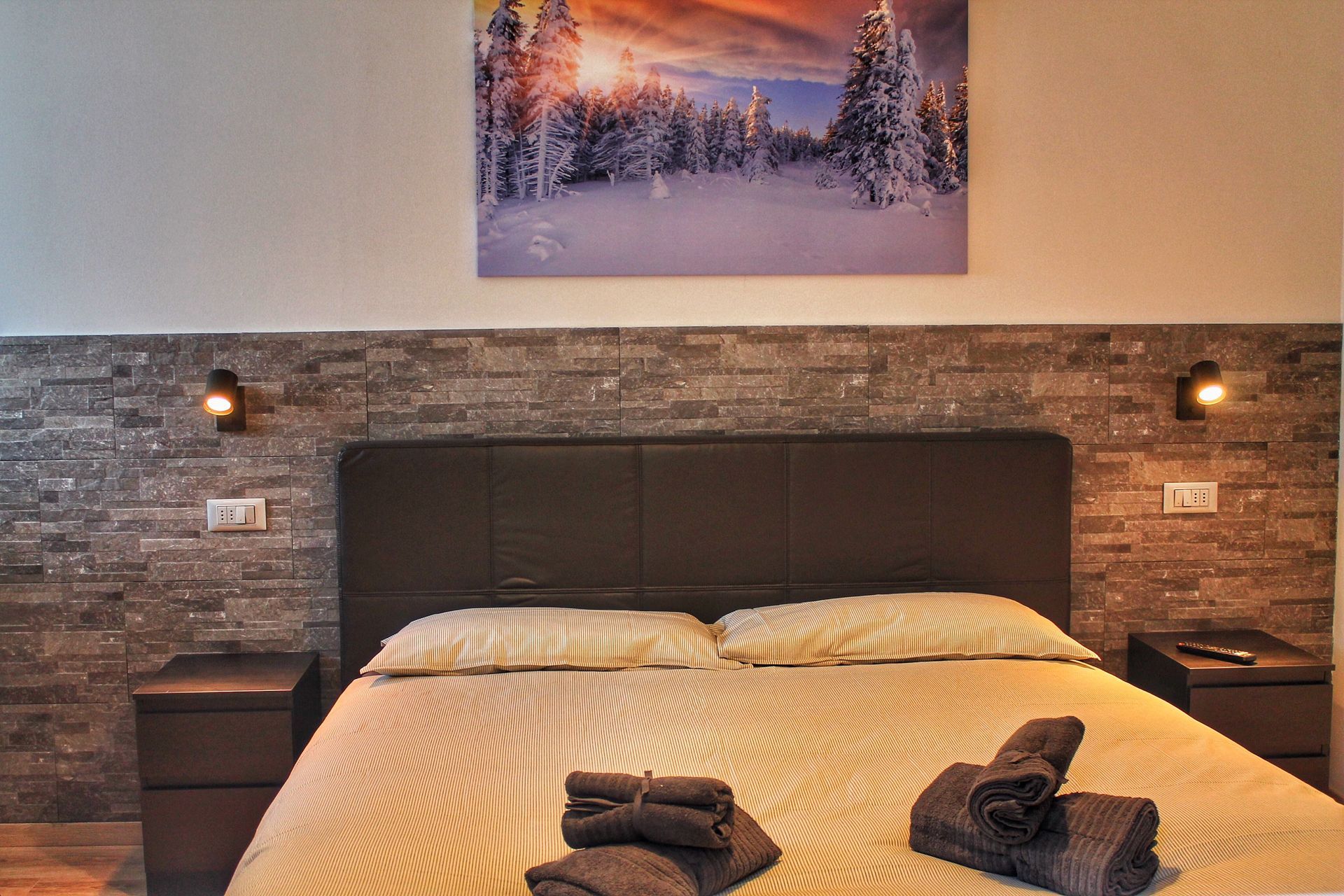 Una camera da letto con un dipinto sul muro sopra il letto