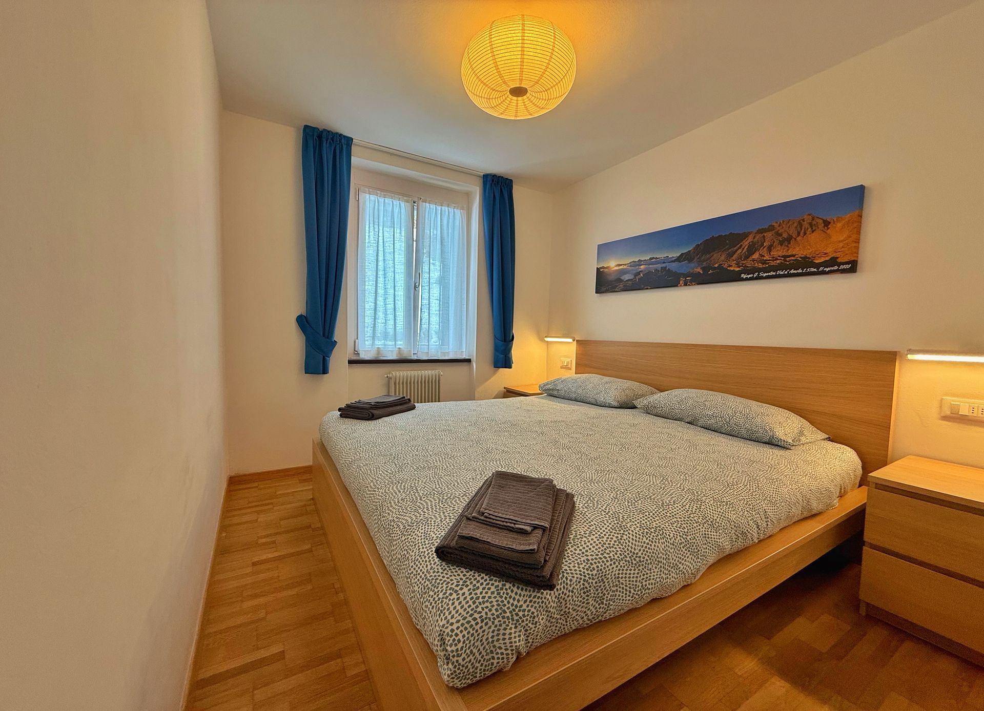 Una camera da letto con un letto grande e un quadro sulla parete soprastante