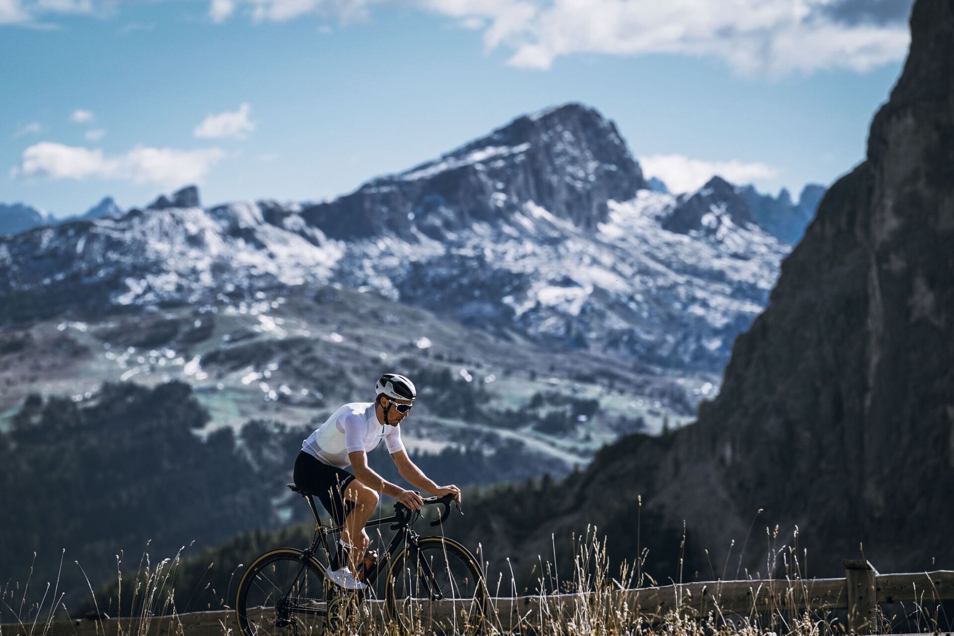 Un uomo sta andando in bicicletta su una strada di montagna.