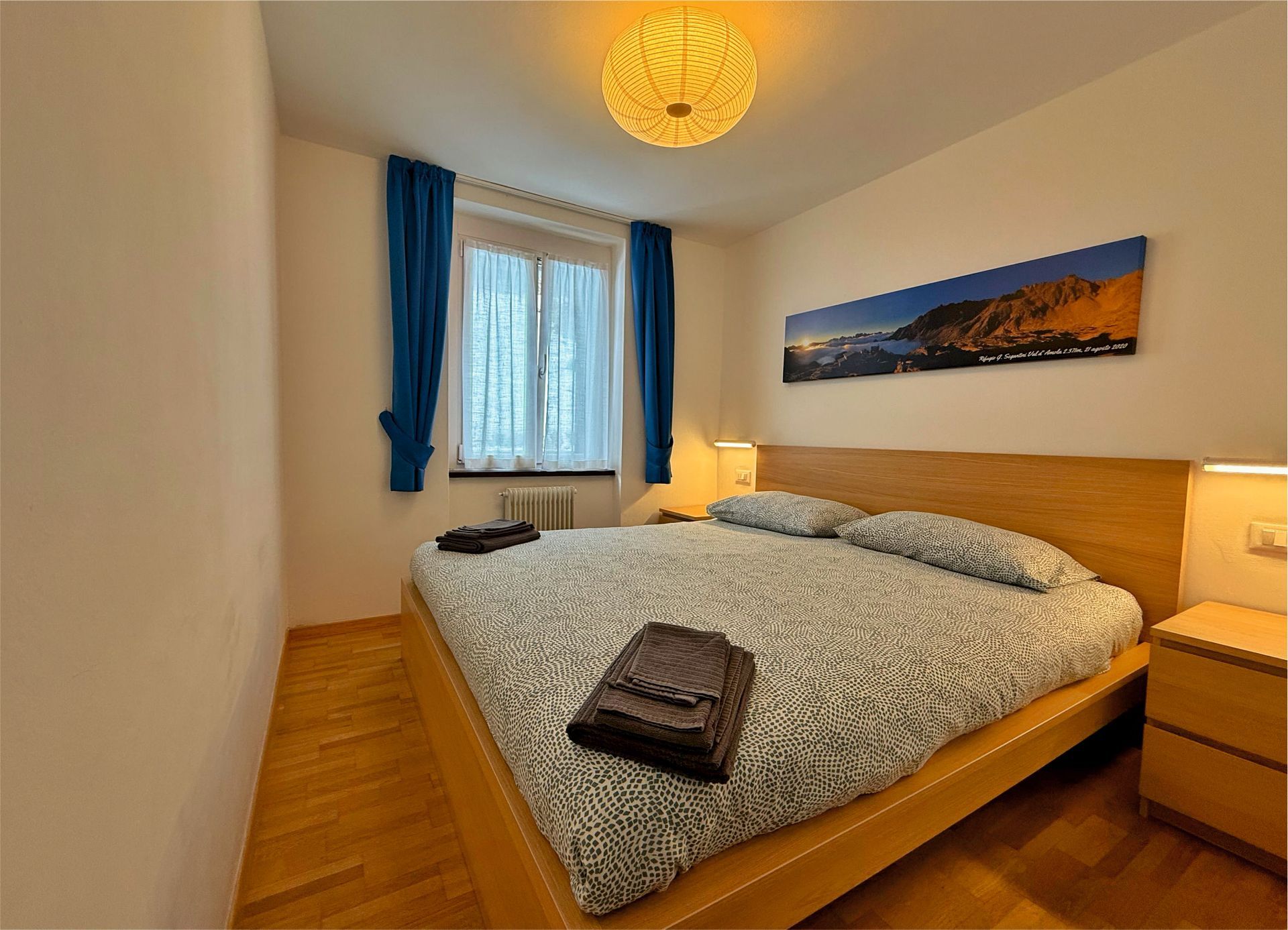 Una camera da letto con un letto grande e un quadro sulla parete soprastante.