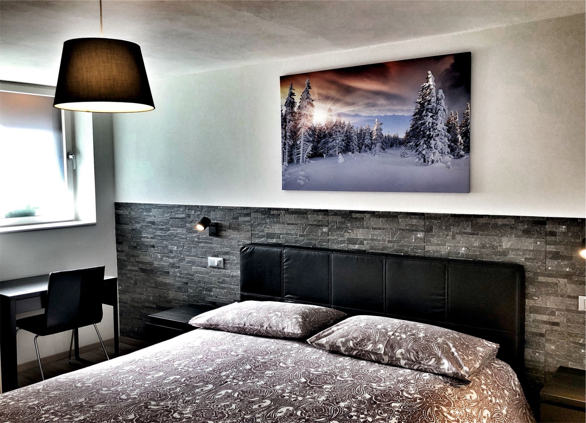 Una camera da letto con un grande dipinto sulla parete sopra il letto