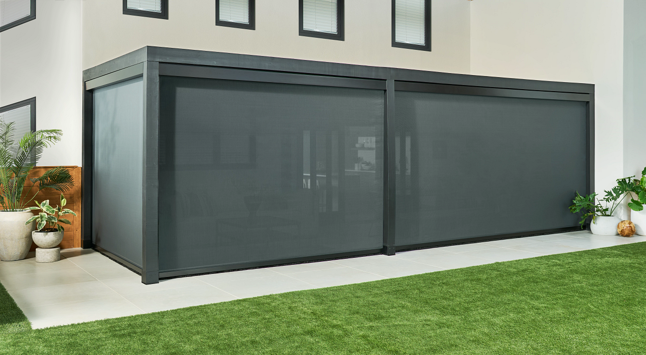 A deck with patio shades from Insolroll® lowered and one shades raised