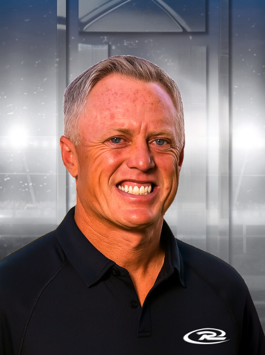 Smiling man in a black polo shirt against a metallic gray background