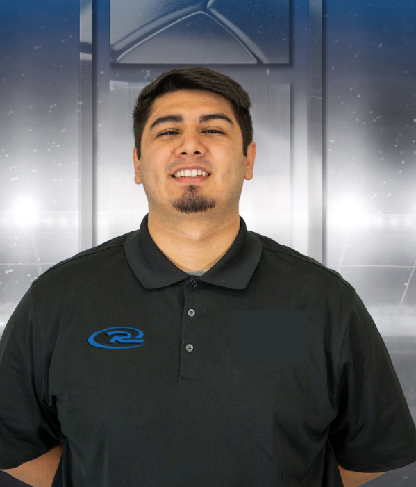 Man in a black polo shirt standing in front of a metallic, industrial backdrop