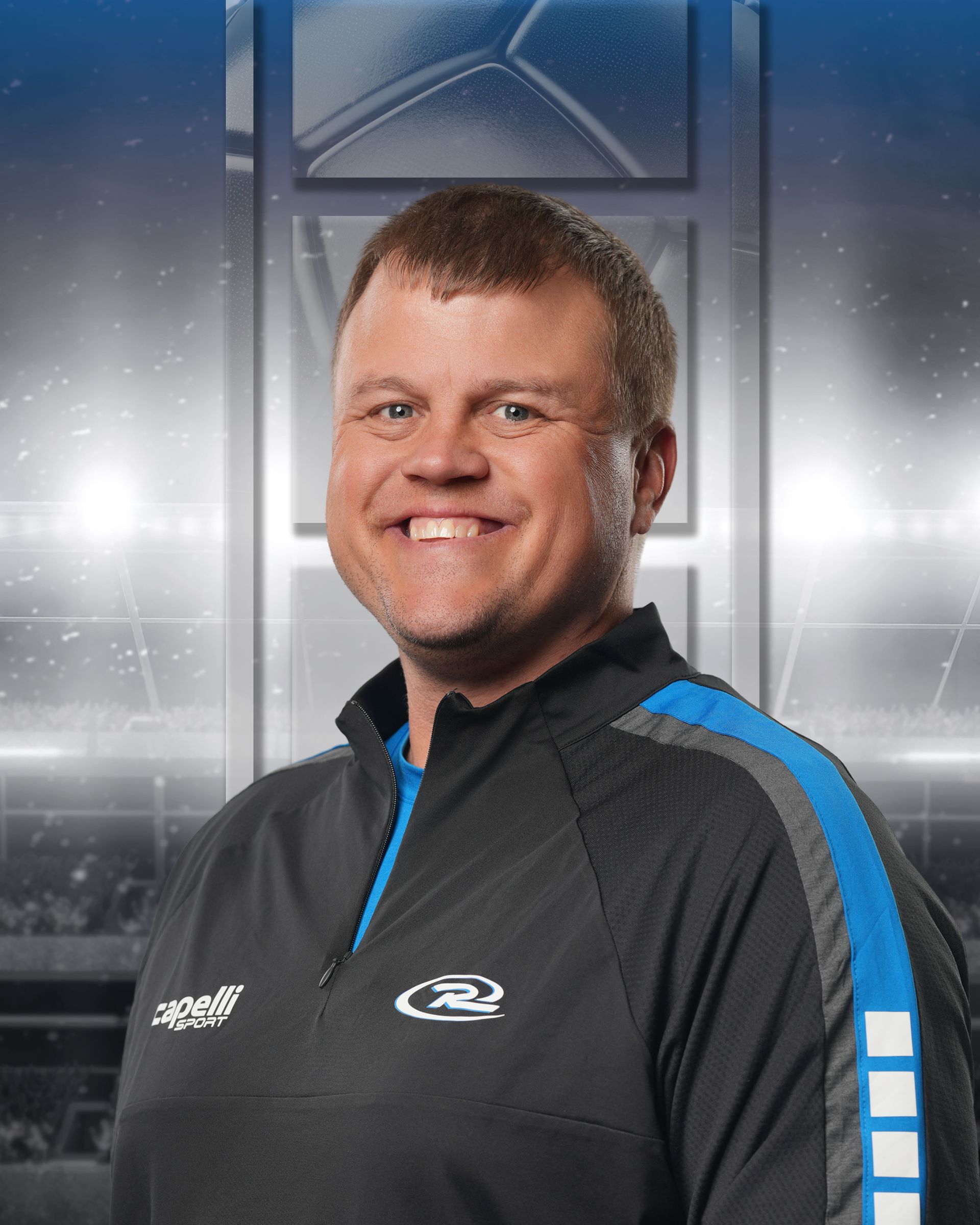 Smiling person in black and blue sports jacket against a metallic studio backdrop