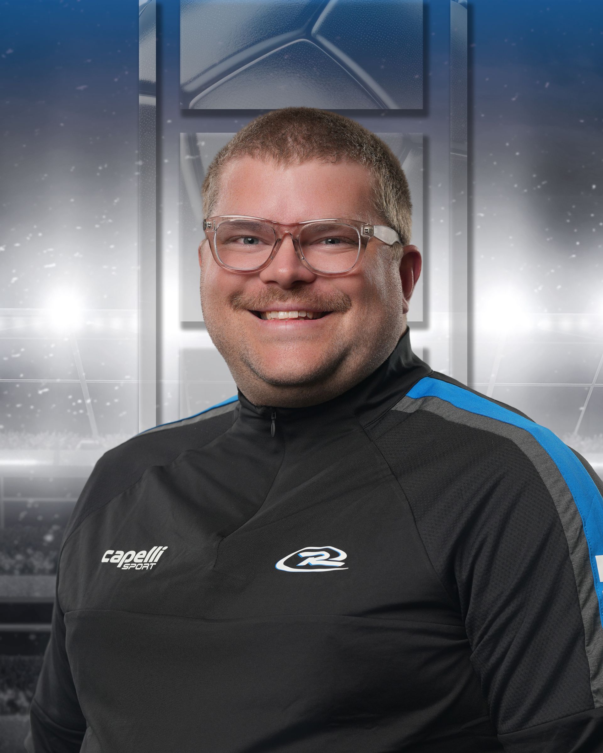 Smiling person in clear glasses wearing a black sports top with blue accents, against a studio backdrop