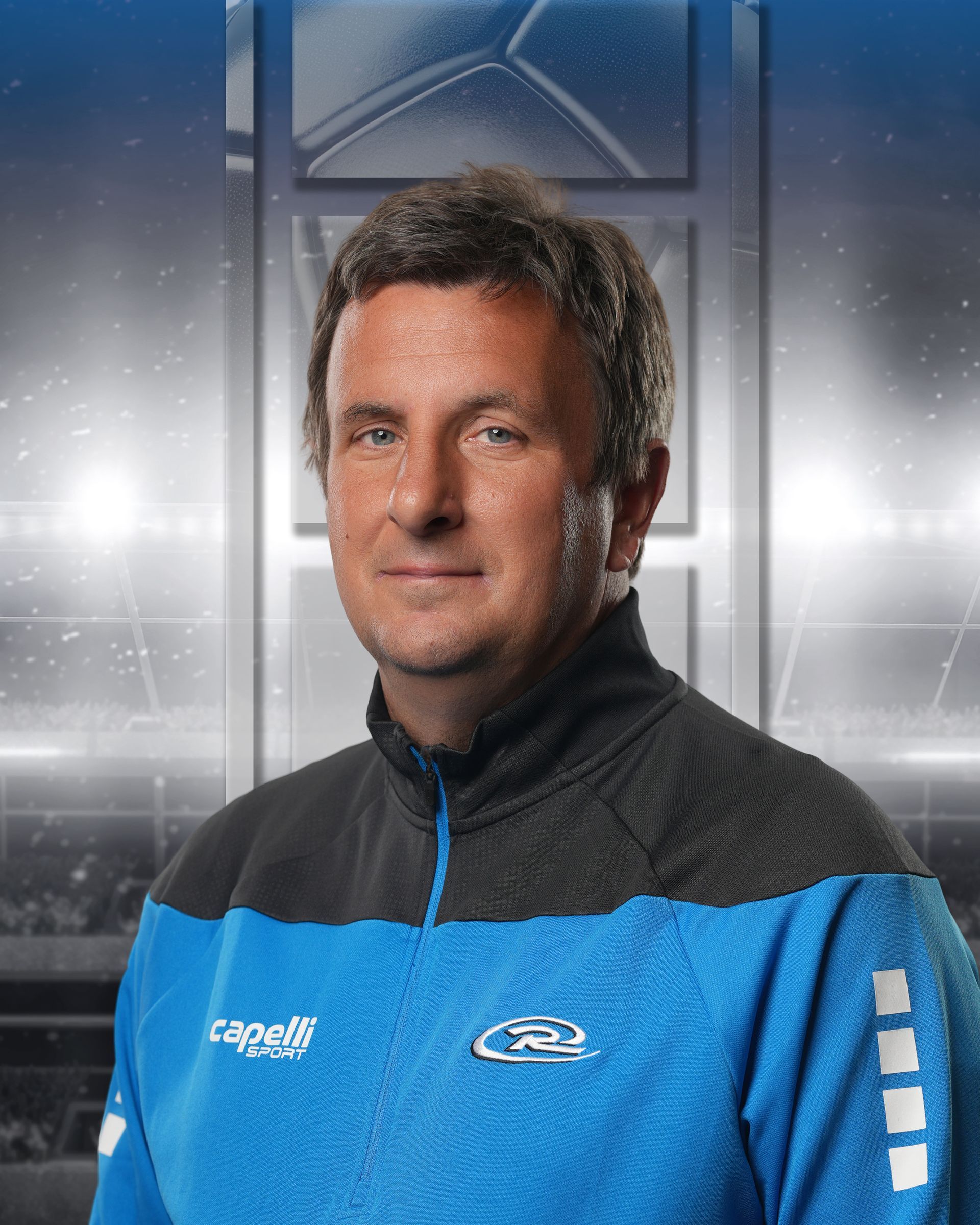 Portrait of a man in a blue and black sports jacket against a stadium-style background