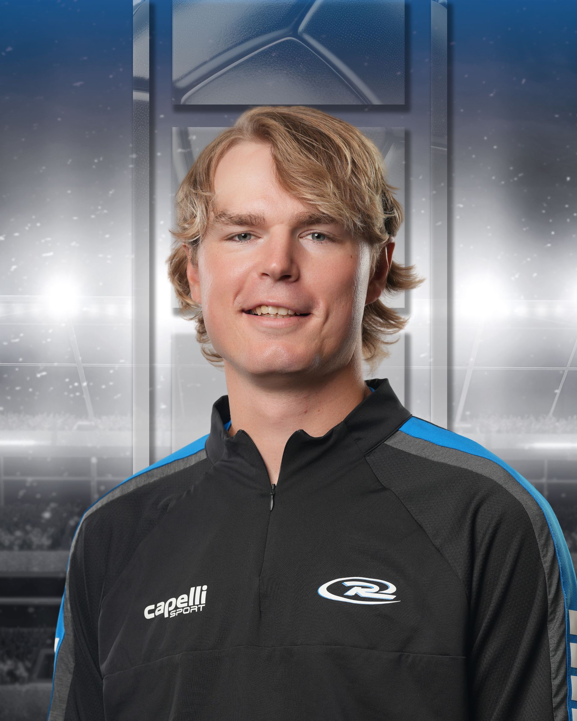 Portrait of a smiling person in a black zip-up jacket against a blue-gray studio backdrop