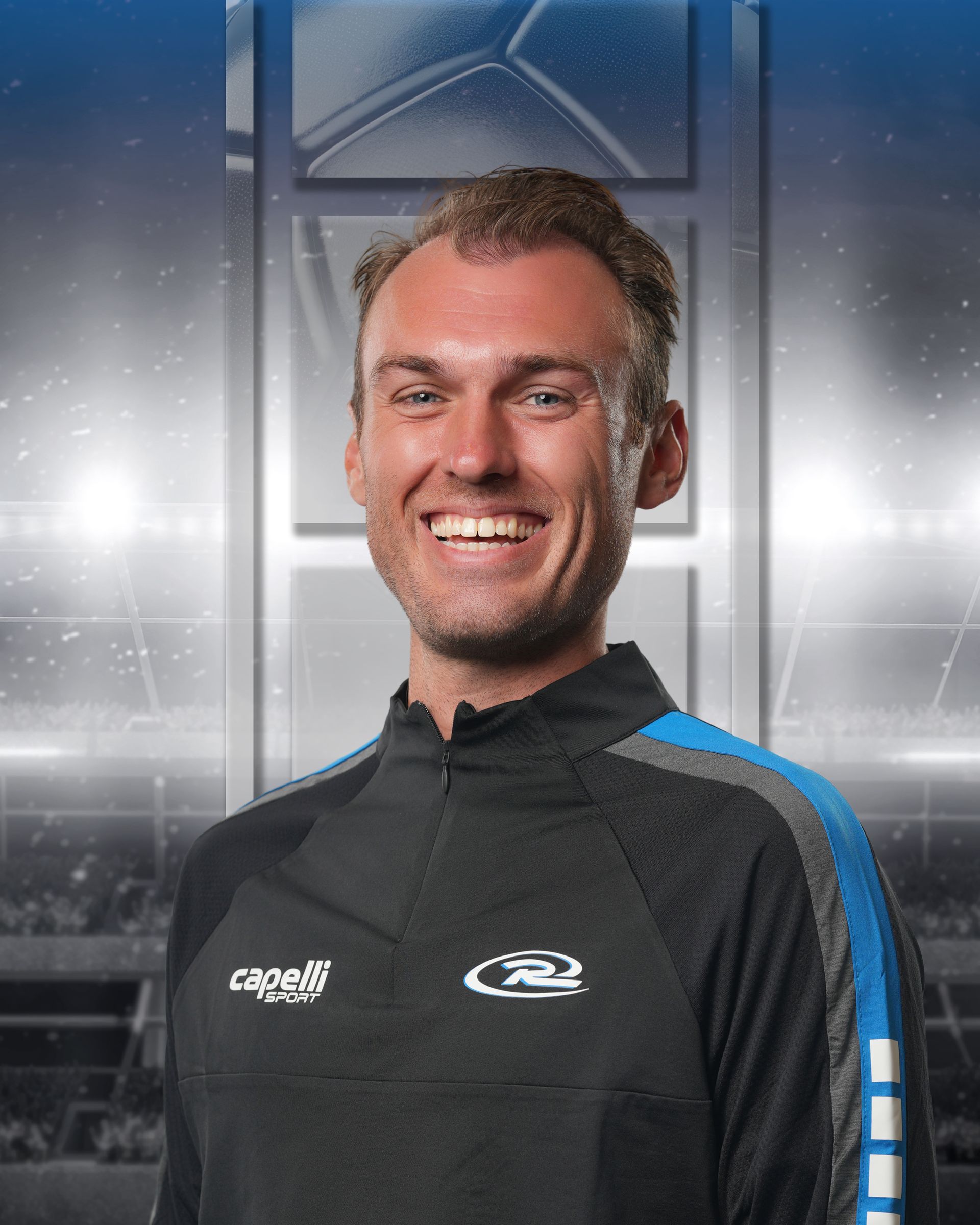 Smiling person in a black and blue sports jacket against a stadium-style background