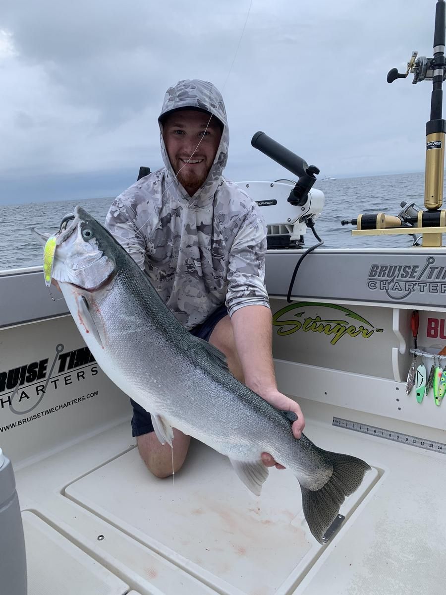 A man is holding a large fish on a boat.