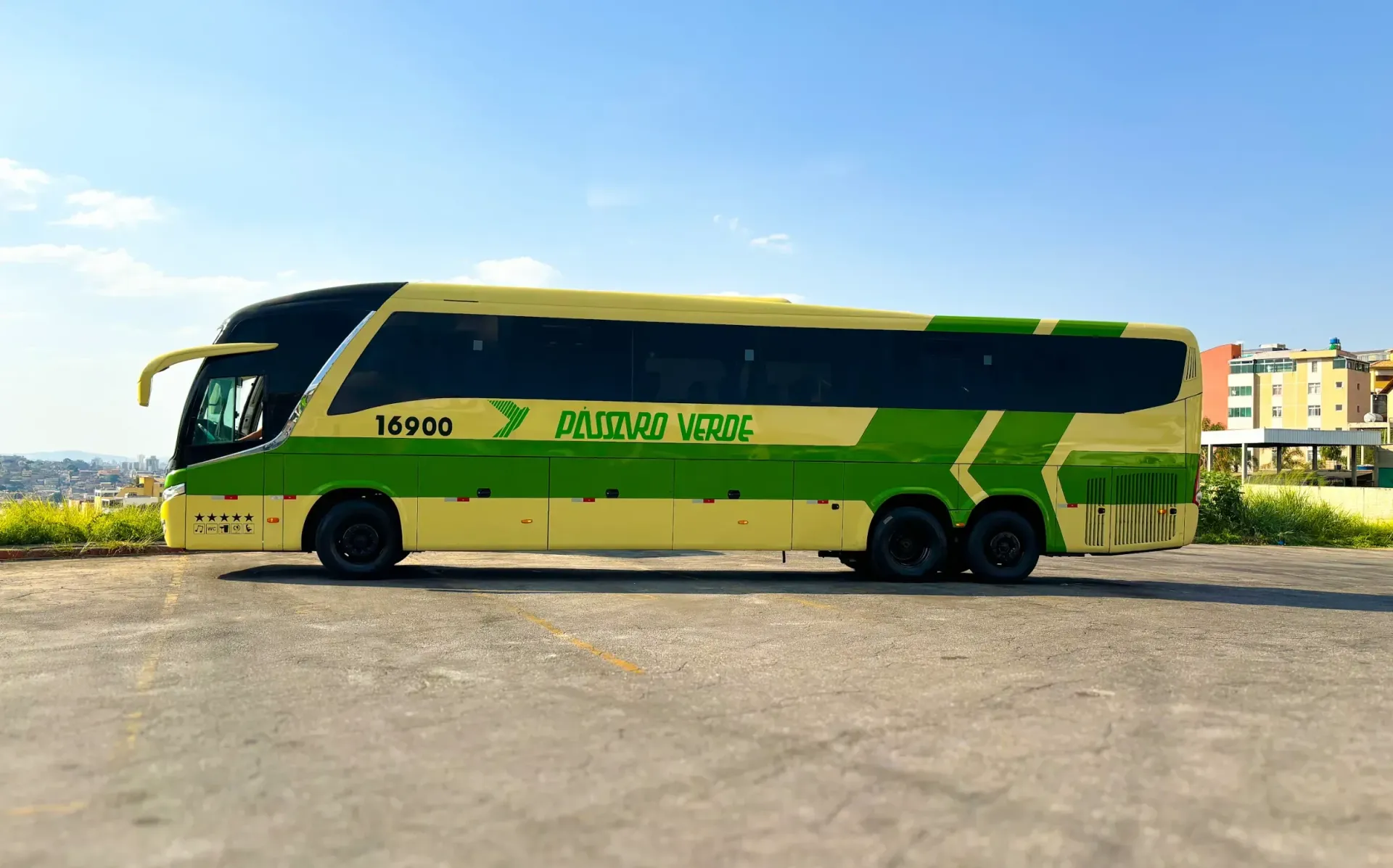 Um ônibus verde e amarelo está estacionado em um estacionamento.
