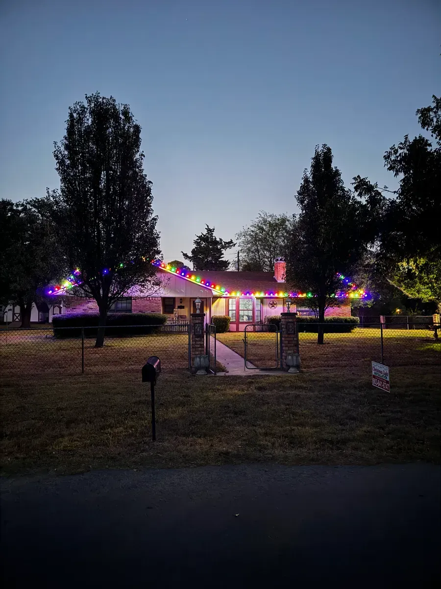 A house is decorated with christmas lights at night.