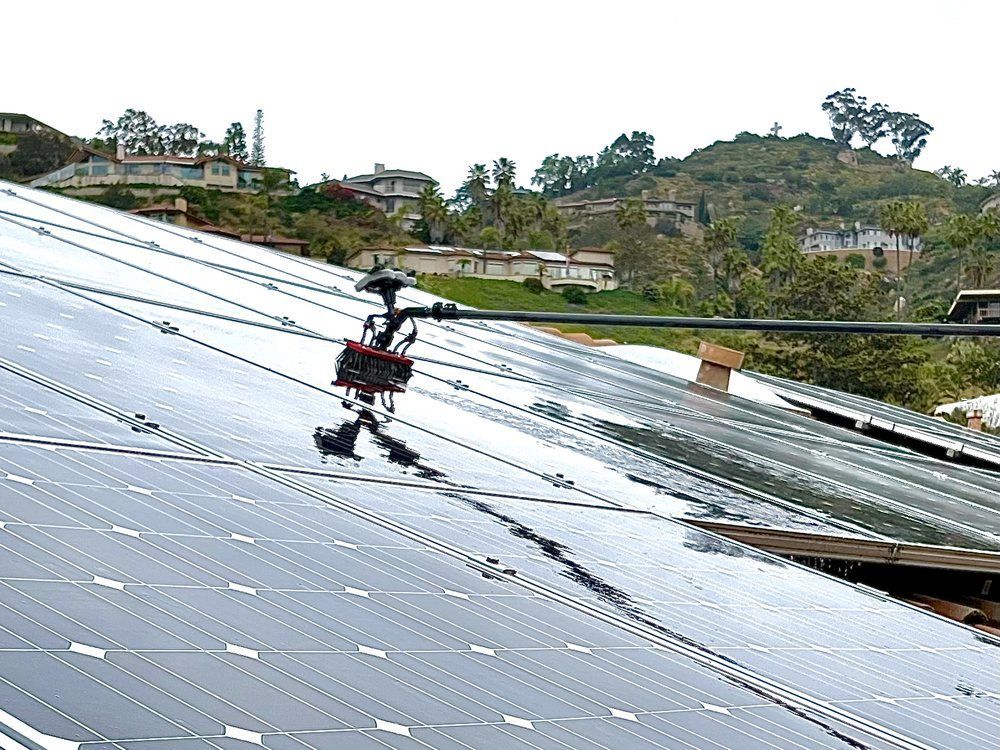 Person in a red harness working on a sloped solar panel roof outdoors
