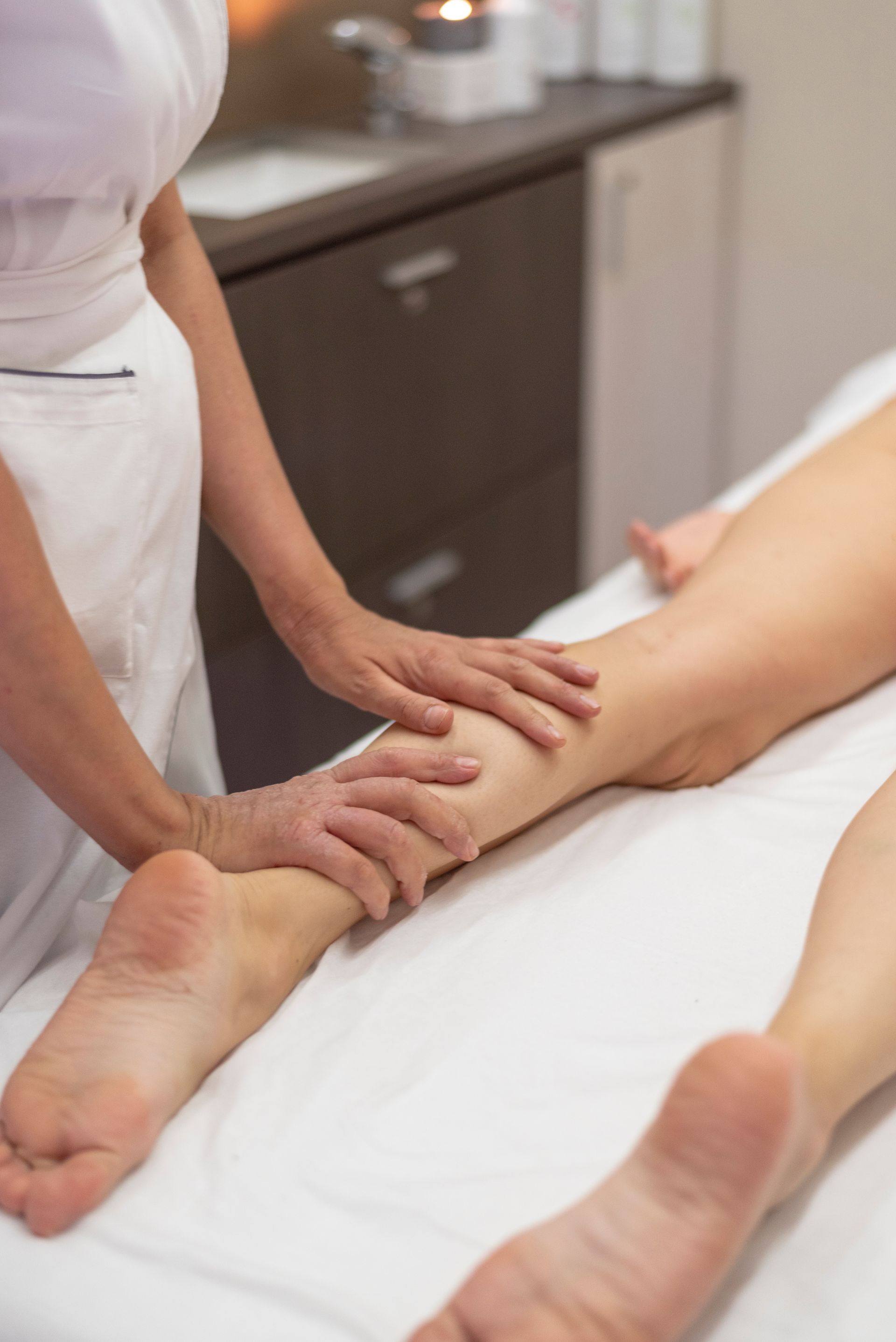 una donna sta facendo un massaggio alle gambe di una persona