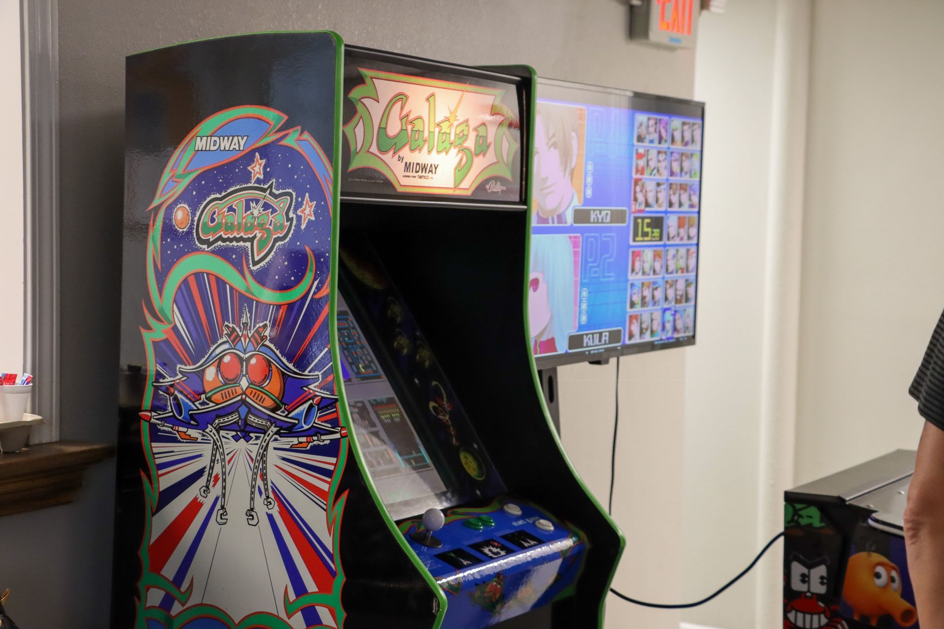 A man is playing a video game on an arcade machine.